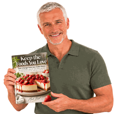 Mark Reed smiling and holding up the book Keep the Foods You Love.